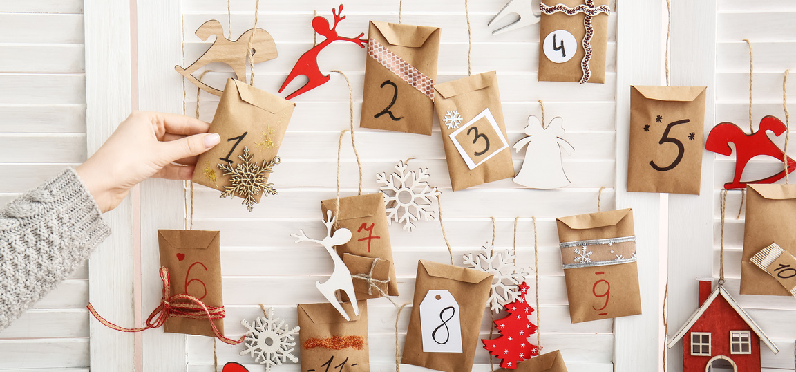 Woman near Christmas Advent Calendar at Home